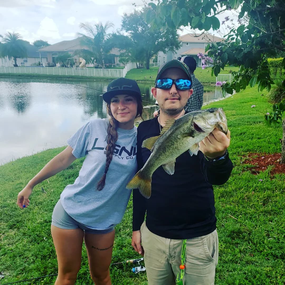 Couple with a largemouth bass at a neighborhood pond